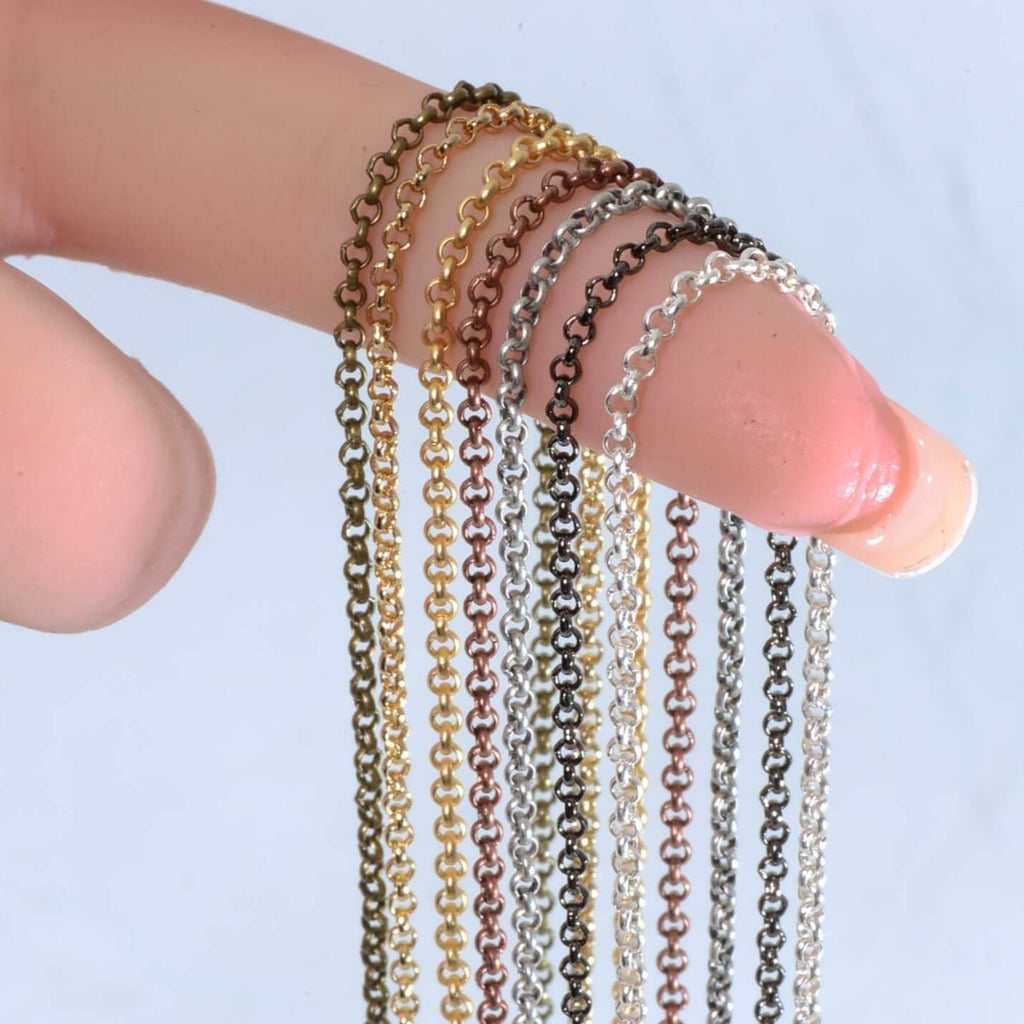 Close-up of 2mm Rolo chain samples in multiple colors, held by a finger, showcasing variety for jewelry making.